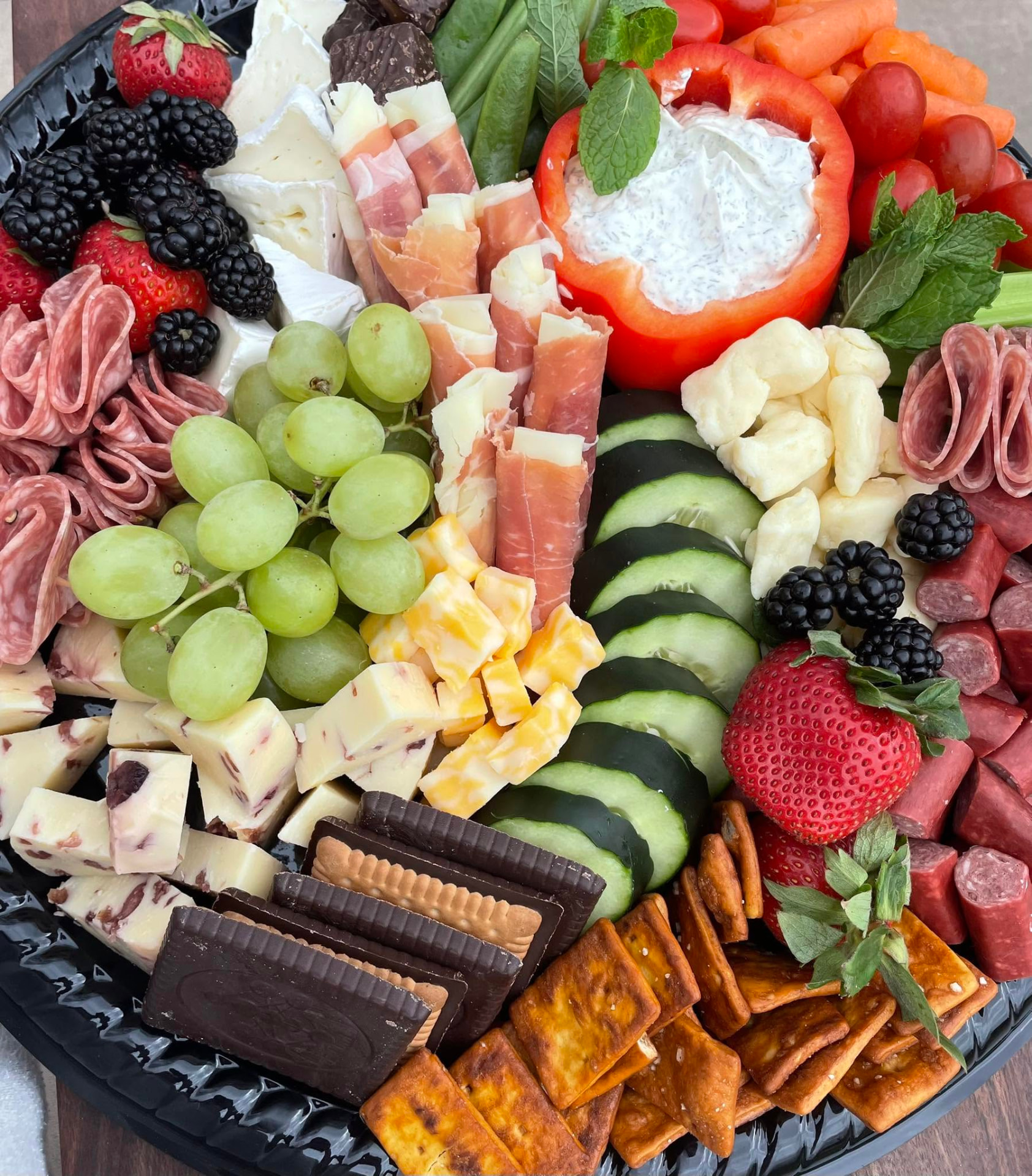 Snack tray with salami roses, brie, grapes, cheese curds, and crackers
