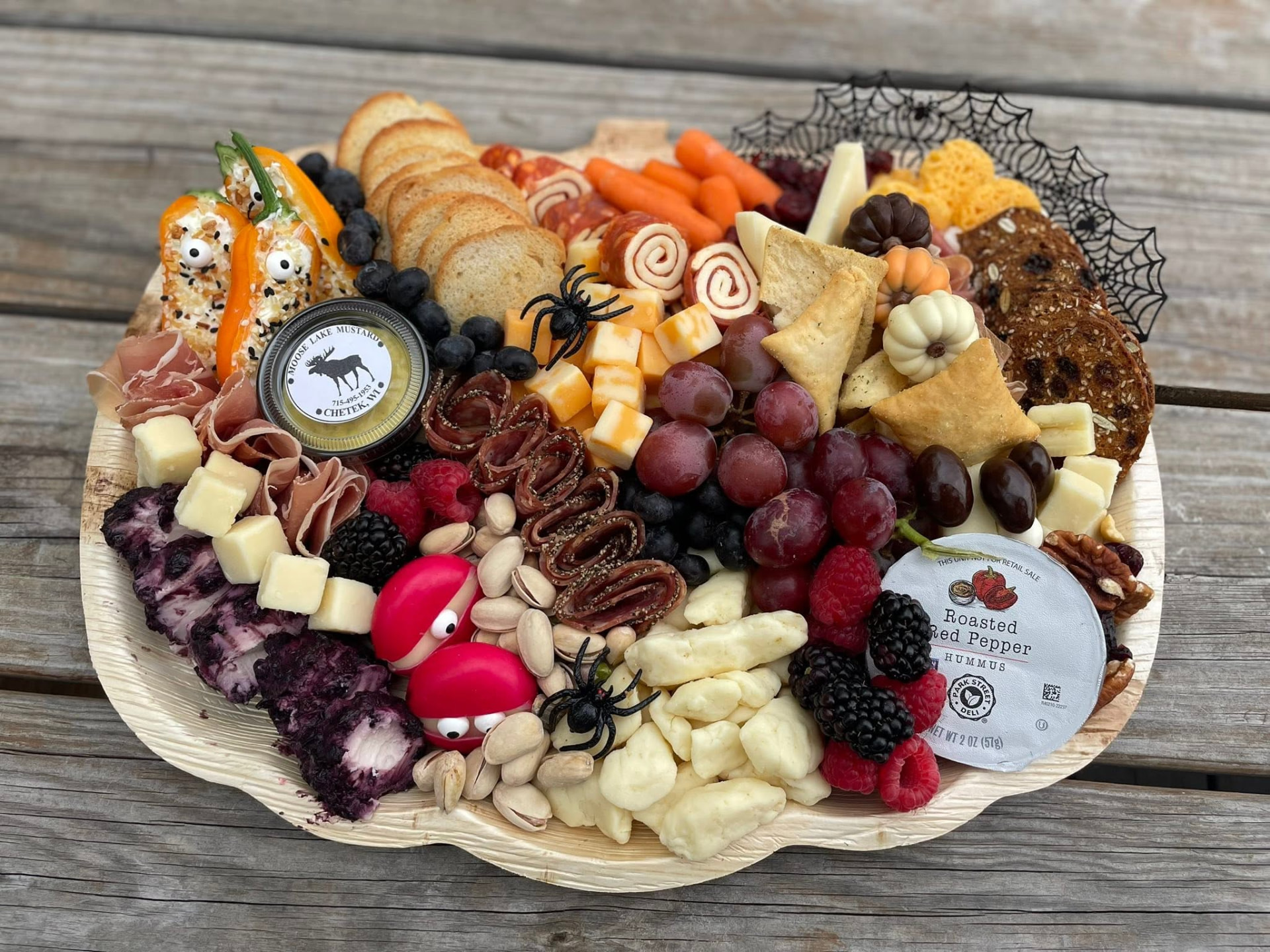 Fall snack board on a pumpkin-shaped tray with cheeses, meats, and fruit