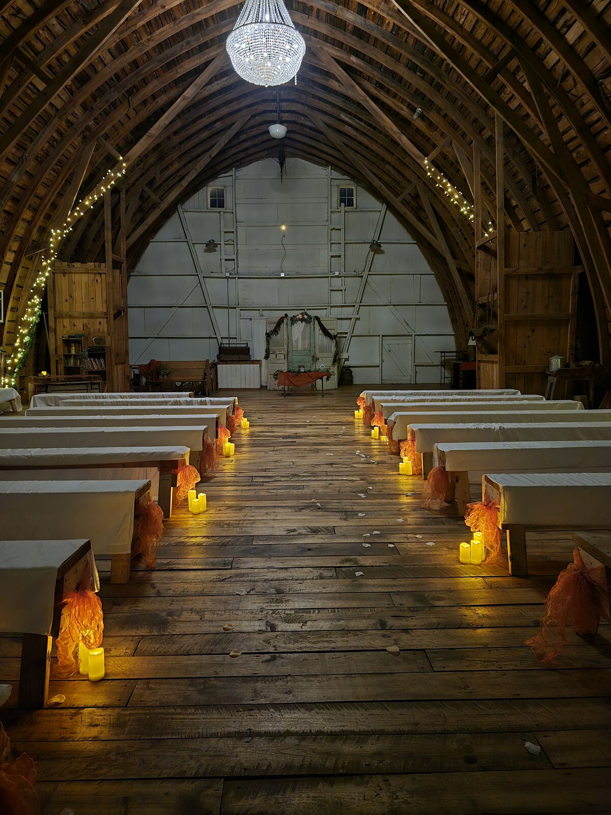 Candlelit wedding aisle in the barn at night