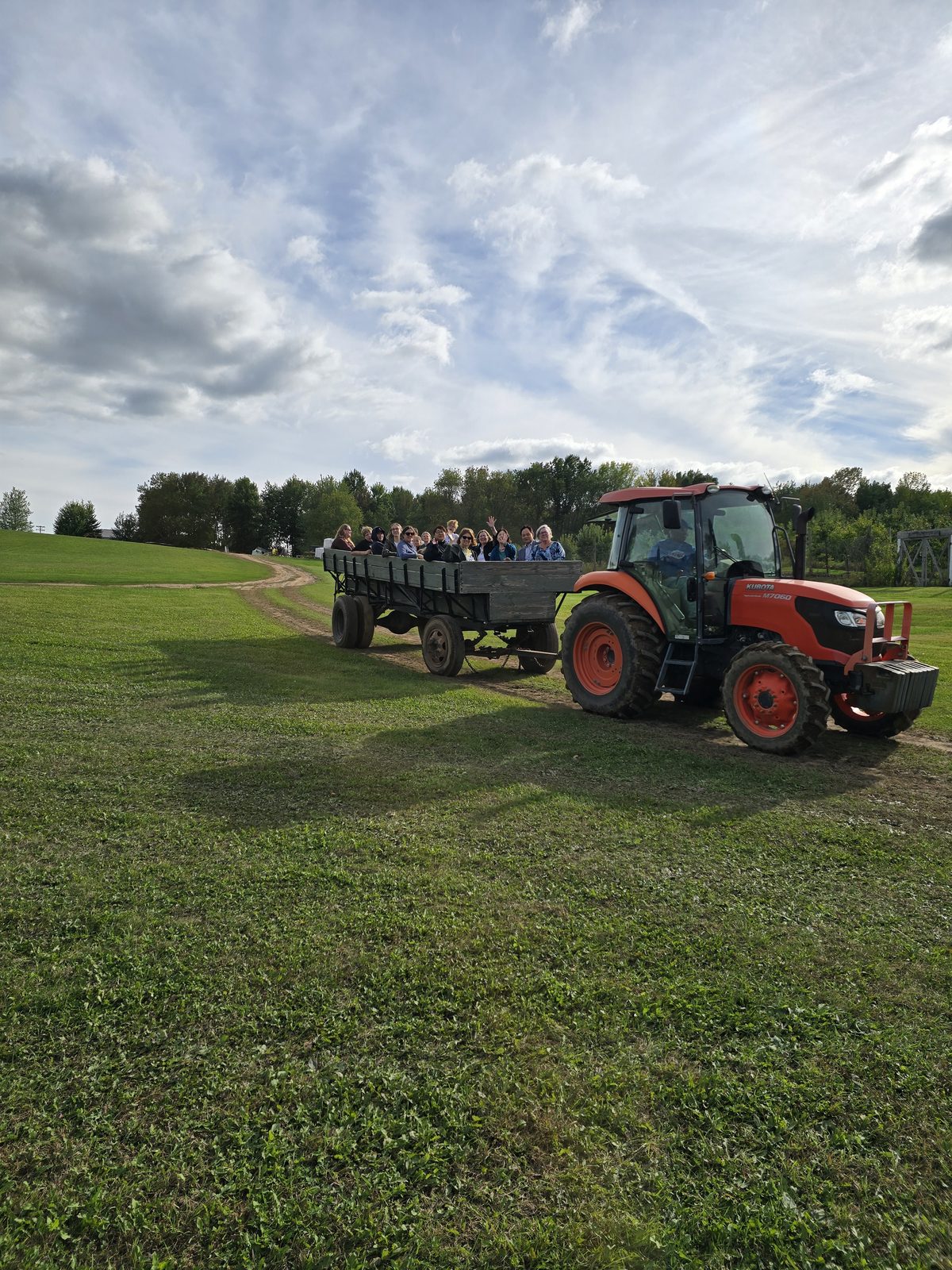 School group enjoying a tractor-pulled wagon ride across the farm